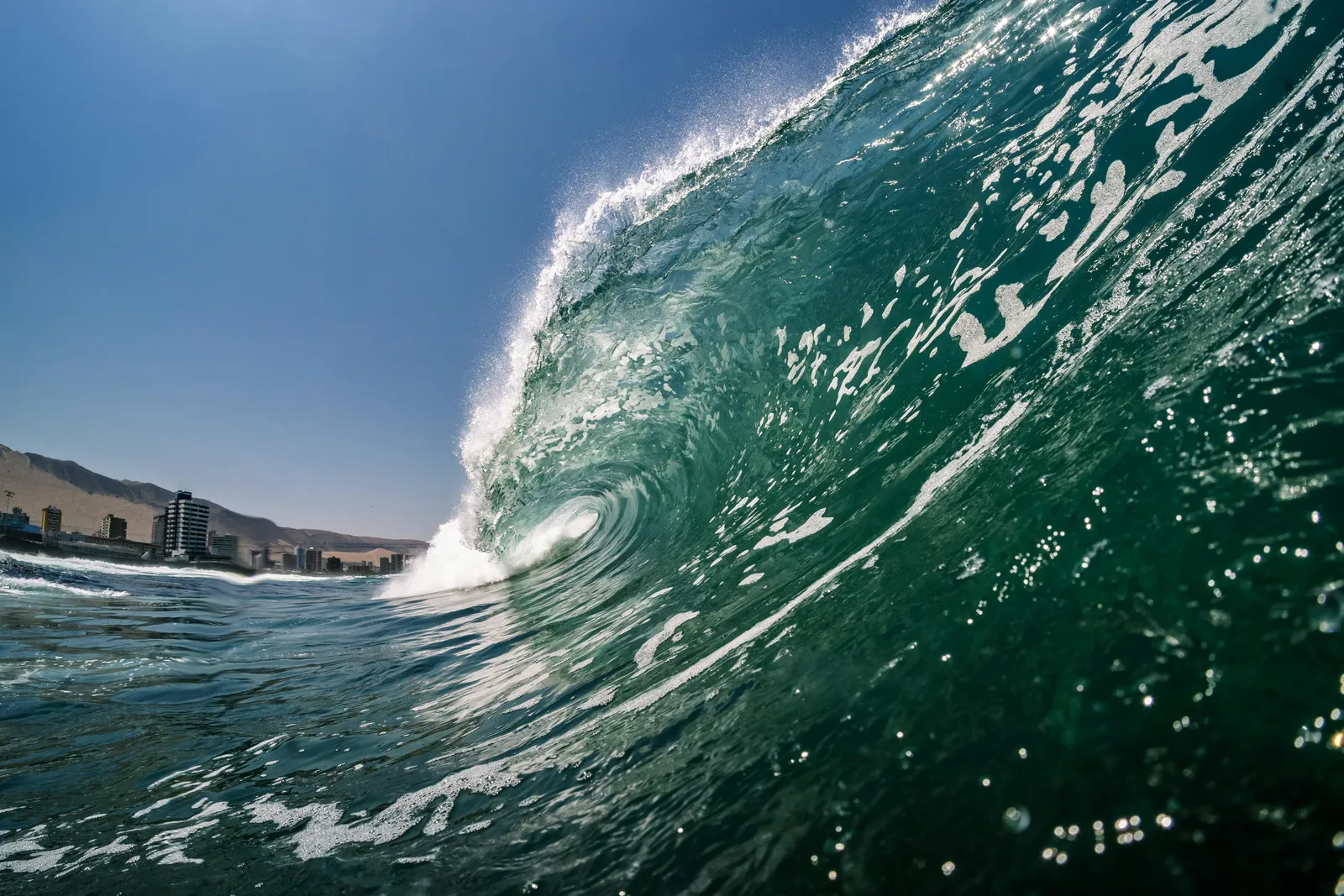 Cold-water Chilean point break with empty lineups and snow-capped backdrop.