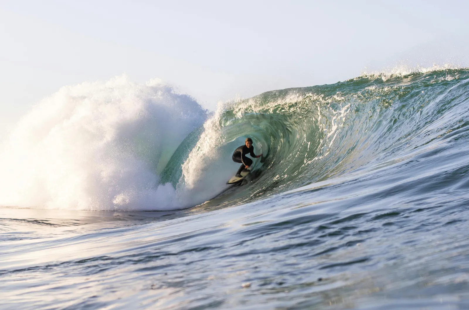 Surfer dropping in on a clean California right at sunset.