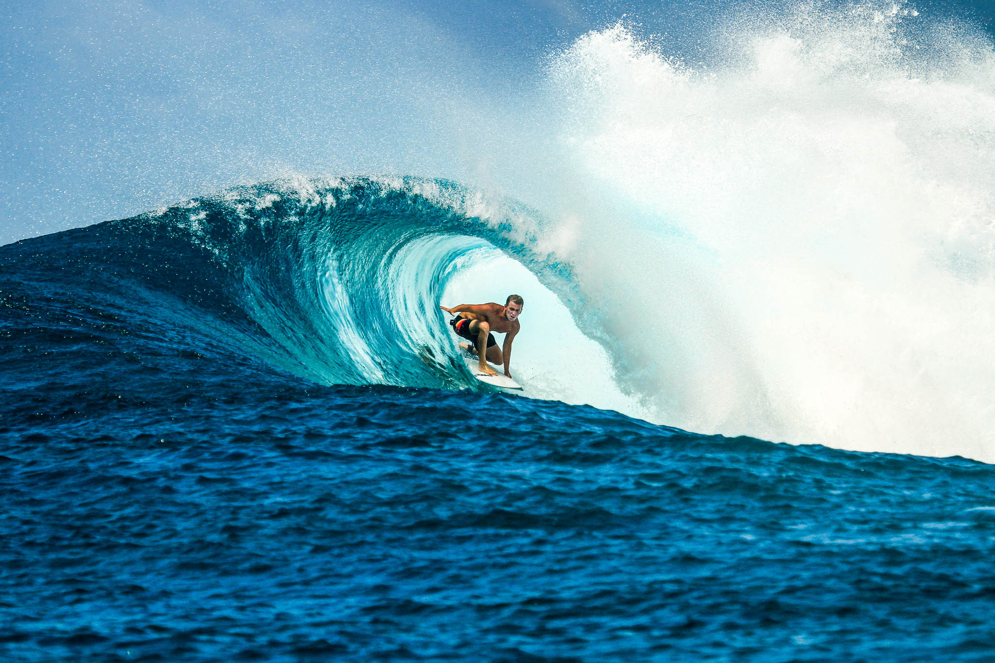 Surfer on perfect blue wave, in the barrel, clean water, Indian Ocean close to Maldivian island Thulusdhoo